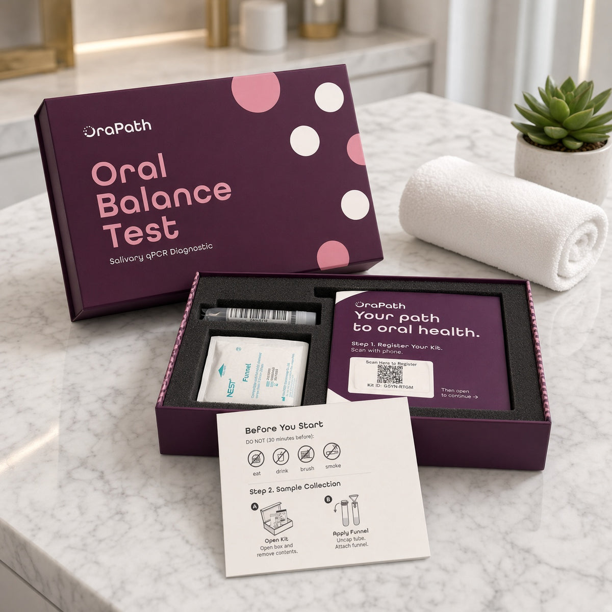 The Oral Balance Test kit open on a bathroom counter, showing the saliva collection tube, funnel, registration card and instruction card.